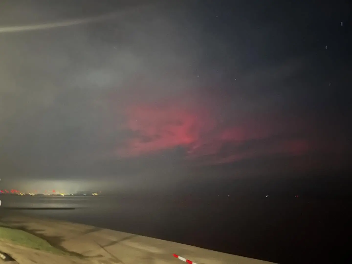 Roze noorderlicht boven de kust bij Delfzijl